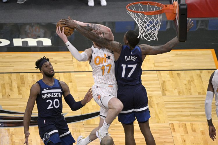 Orlando Magic forward Ignas Brazdeikis (17) is fouled by Minnesota Timberwolves center Ed Davis (17), right, while going up for a shot as Timberwolves forward Josh Okogie (20) watches during the second half of an NBA basketball game, Sunday, May 9, 2021, in Orlando, Fla. (AP Photo/Phelan M. Ebenhack)